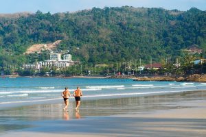 older couple running on beach
