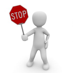 small figure holding stop sign